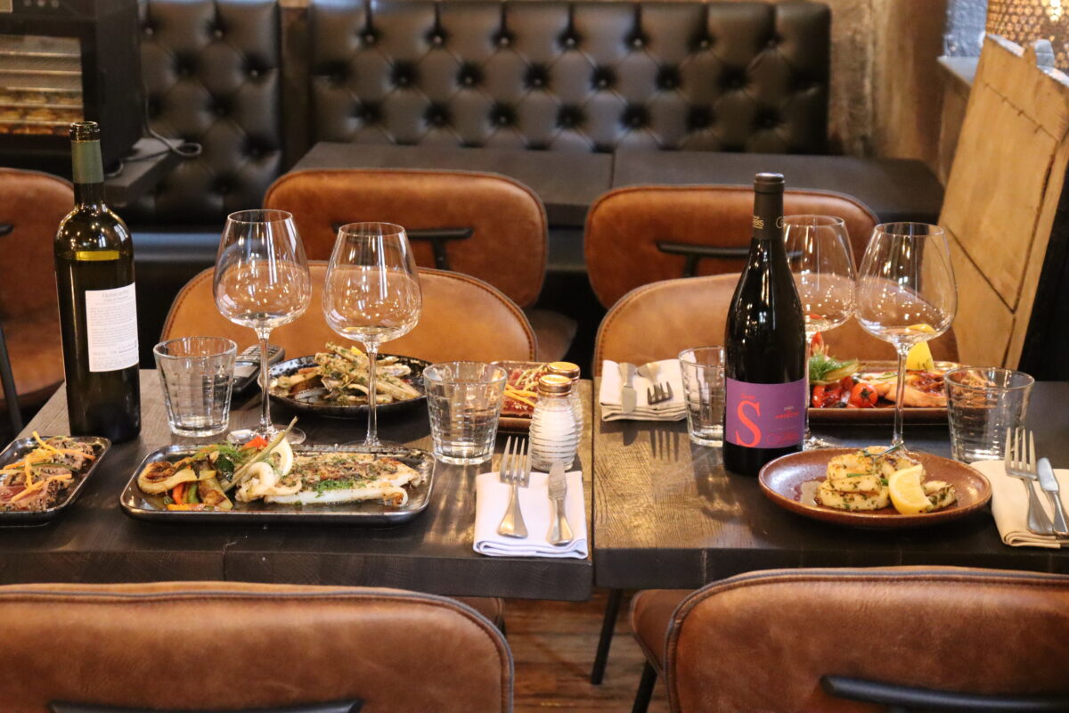 tables de restaurant avec de bons plats cuits a la plancha et du vin