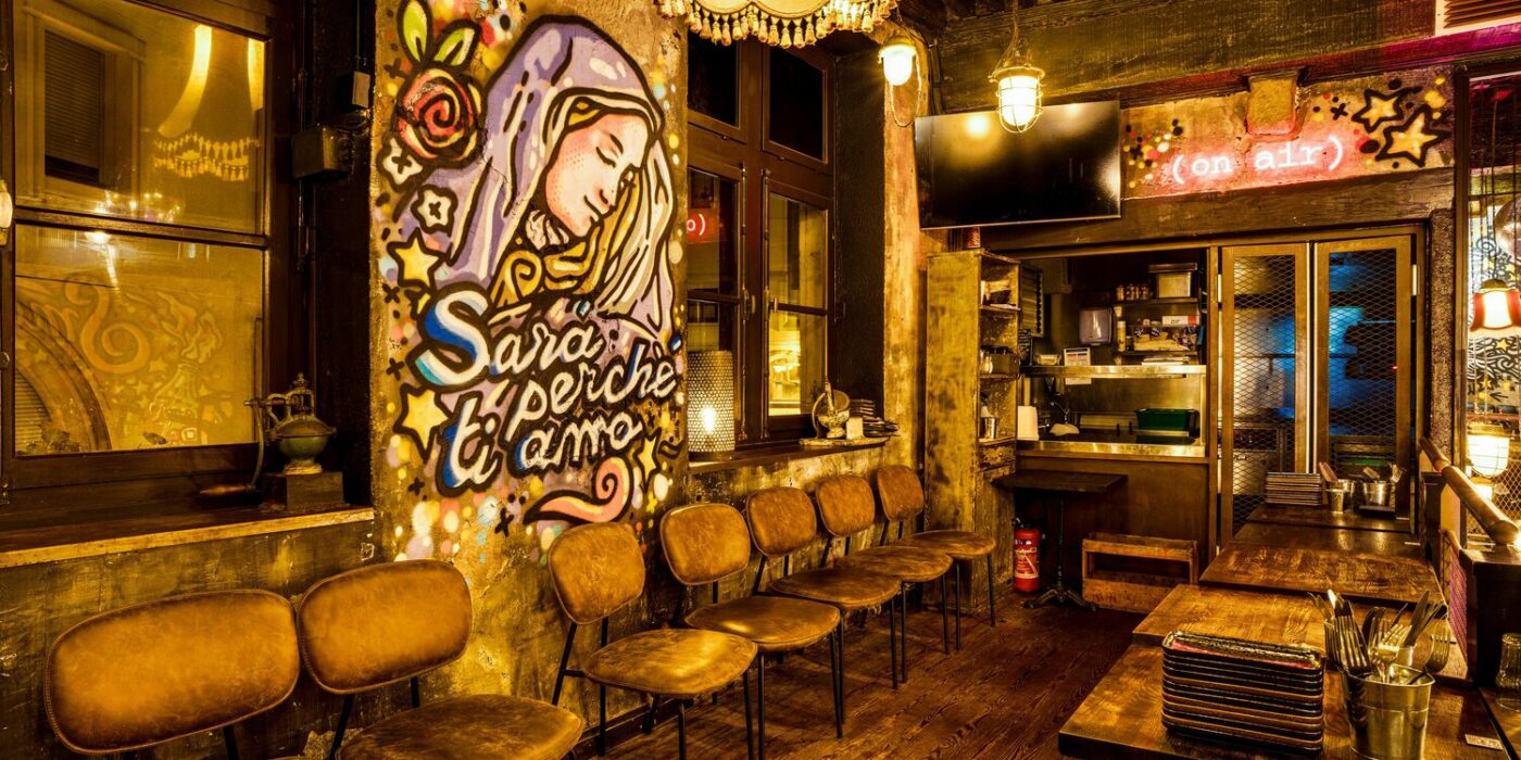 Intérieur de restaurant vibrant avec fresque murale, éclairage unique et sièges à Casa Soho.